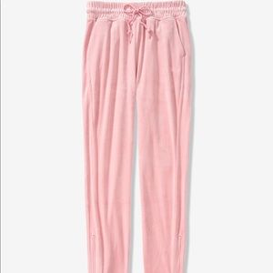 Pink velour joggers with zipper bottom.